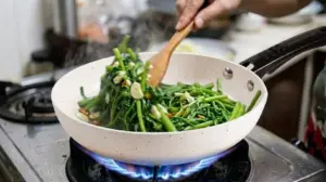 So Sánh Chảo Ceramic và Teflon - Lớp Phủ Nào An Toàn Hơn? 2 Chảo ceramic Kim Hằng xào rau muống trên bếp gas lửa lớn không sinh khí độc.